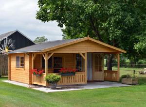 a wooden cabin with a porch and a roof at Camping 't Bosch in Zelhem