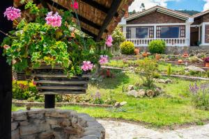 un jardín con flores rosas en una casa en Villa Patty, en Tibasosa