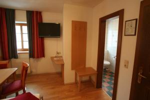 een kamer met een badkamer met een toilet en een televisie bij Hotel Engl in Innsbruck