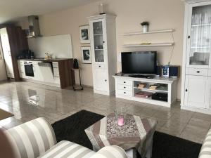 sala de estar con TV y mesa en una habitación en Kleine Perle, Villa Sonnegarten, en Boltenhagen