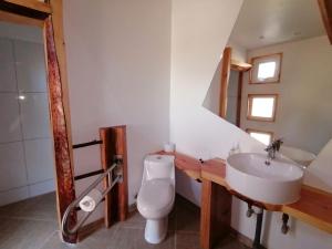 y baño con aseo blanco y lavamanos. en Hostería de la Patagonia, en Chile Chico