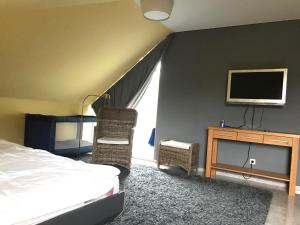 Un dormitorio con una cama y un televisor en una pared. en Kleine Perle, Villa Sonnegarten, en Boltenhagen