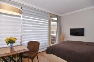 een slaapkamer met een bed, een tafel en een raam bij Westerländer Nest in Westerland