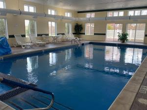 a large swimming pool with blue water in a building at Hometown Inn Indian River in Indian River