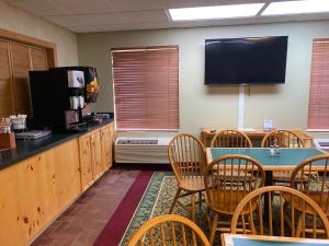 a dining room with a table and chairs and a tv at Hometown Inn Indian River in Indian River