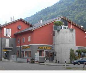 a red building with a red store on a street at Ristorante Con alloggio Val Sole in Acquarossa