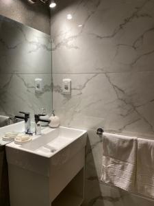 W białej łazience znajduje się umywalka i lustro. w obiekcie Grand Hotel Mariscala w mieście Mariscala