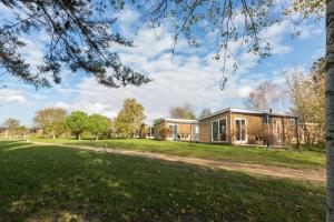 een huis in een park met een boom bij Vakantiepark Fort den Haak in Vrouwenpolder