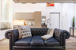 米蘭的住宿－金色威望公寓，客厅里一张黑色皮沙发