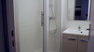 un baño con ducha y lavabo en travelski home classic - Résidence Boedette, en Les Menuires