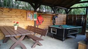 a patio with a table and a stove and a picnic bench at Leśny Domek Męcikał in Męcikał