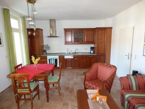 eine Küche und ein Wohnzimmer mit Tisch und Stühlen in der Unterkunft "Villa Loni" Ferienwohnung 7 in Ostseebad Sellin