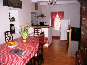 una cocina con mesa y mantel a cuadros rojos en Chambres d'Hôtes La Roumec, en Escandolières