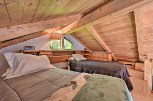 two beds in a room with wooden ceilings at Remote Cabin with Fire Pit 3 Miles to Stowe Mtn! in Stowe