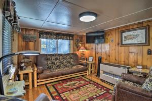 un soggiorno con divano e tavolo di Riverfront Grayling Retreat with Fire Pit and Dock! a Bucks