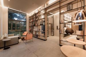 a room with a library with a table and chairs at Lettera Hotel in Medellín