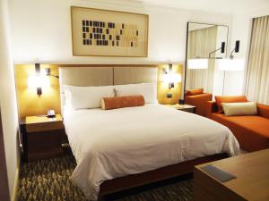 テグシガルパにあるHotel Real Intercontinental Tegucigalpa, an IHG Hotelの大きなベッドとソファが備わるホテルルームです。