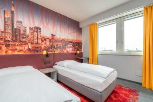 pokój hotelowy z 2 łóżkami i obrazem na ścianie w obiekcie Campanile Frankfurt Offenbach w mieście Offenbach
