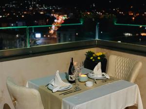 a table with a white table cloth and a bottle of wine at Kuint Hotel in Peje