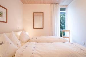 two beds in a room with a window at Rosenblüte in Lindau