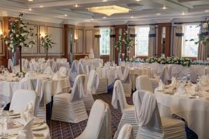 a banquet hall with white tables and chairs at Manor Hotel Solihull, BW Signature Collection in Bickenhill