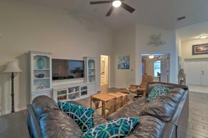 a living room with a leather couch and a tv at Breezy Gulf Coast Getaway about 4 Mi to Beach Park in Port Charlotte