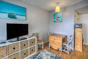 ein Wohnzimmer mit einem Flachbild-TV und einem Tisch in der Unterkunft Cozy Beachfront Condo with WiFi, Views and Pool Access in Myrtle Beach
