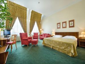 una camera d'albergo con letto, scrivania e sedie di EA Hotel Rokoko a Praga