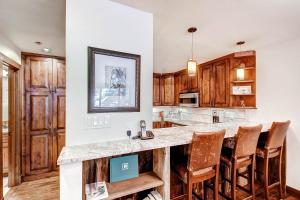 a kitchen with wooden cabinets and a large island at Kiva Lodge by East West Hospitality in Beaver Creek