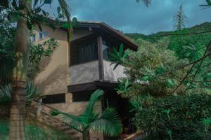 una casa en medio de un bosque en Doce Cabana Pousada, en Barra de Ibiraquera