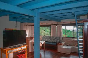 un soggiorno con letto a soppalco e TV di Doce Cabana Pousada a Barra de Ibiraquera