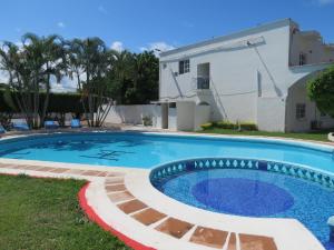 a swimming pool in front of a house at Hotel Albri by Rotamundos in Tecolutla