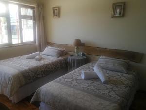 um quarto com 2 camas e uma janela em Bonani B & B na Cidade do Cabo
