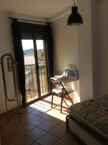 1 dormitorio con mesa y puerta a un balcón en LA MIRADA DE MORA, en Mora de Rubielos