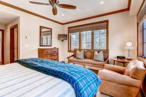 a bedroom with a bed and a chair and a window at Oxford Court by East West Hospitality in Beaver Creek