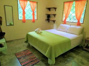 Cabo Matapalo的住宿－Four Monkeys Eco Lodge - Jungle & Beach，一间卧室设有一张床和两个窗户。