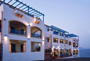 un edificio blanco con el océano en el fondo en Romantica Hotel en Agia Pelagia - Citera