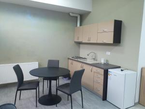 een kleine keuken met een tafel en stoelen en een wastafel bij negris2 in Bîrlad