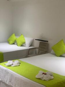 um quarto com duas camas com toalhas em HOTEL CASA GARCES em Cartagena de Indias