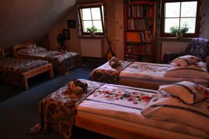 um quarto com três camas e uma estante de livros em AGROTURYSTYKA TEOSIOWO em Pobiedna