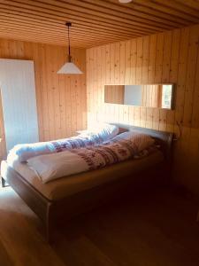 a bedroom with a bed in a wooden wall at Casa Alpetta in Flumserberg