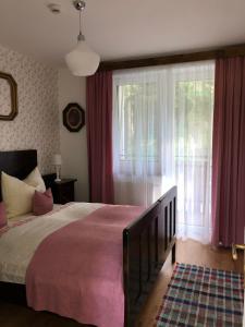 Un dormitorio con una cama grande y una ventana en CHATA PODLESOK en Hrabušice