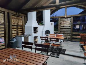 un patio con mesas y sillas y una chimenea en Siesta Pension en Miercurea-Ciuc