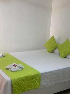 un letto con una coperta verde e un asciugamano sopra di HOTEL CASA GARCES a Cartagena de Indias