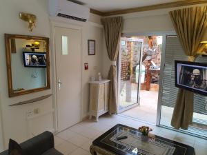 ein Wohnzimmer mit einem Tisch, einem Spiegel und einem TV in der Unterkunft Thai villa eilat - וילה תאי אילת in Eilat