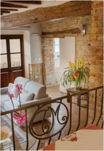 ein Wohnzimmer mit einem Sofa und einem Tisch mit Blumen in der Unterkunft Il Giardino sul Tetto B&B in Guarene