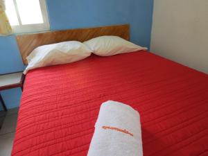 a red bed with a white towel on it at Hotel Albri by Rotamundos in Tecolutla
