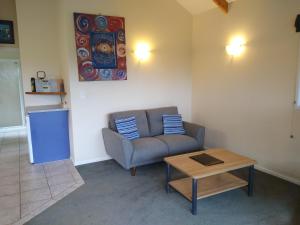 a living room with a couch and a table at Kerigold Secluded Chalets Motel in Kerikeri