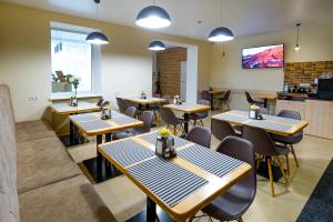 a restaurant with tables and chairs and a kitchen at Rooms Hotel in Vinnytsya