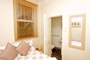 A bed or beds in a room at Cunard Guest House 